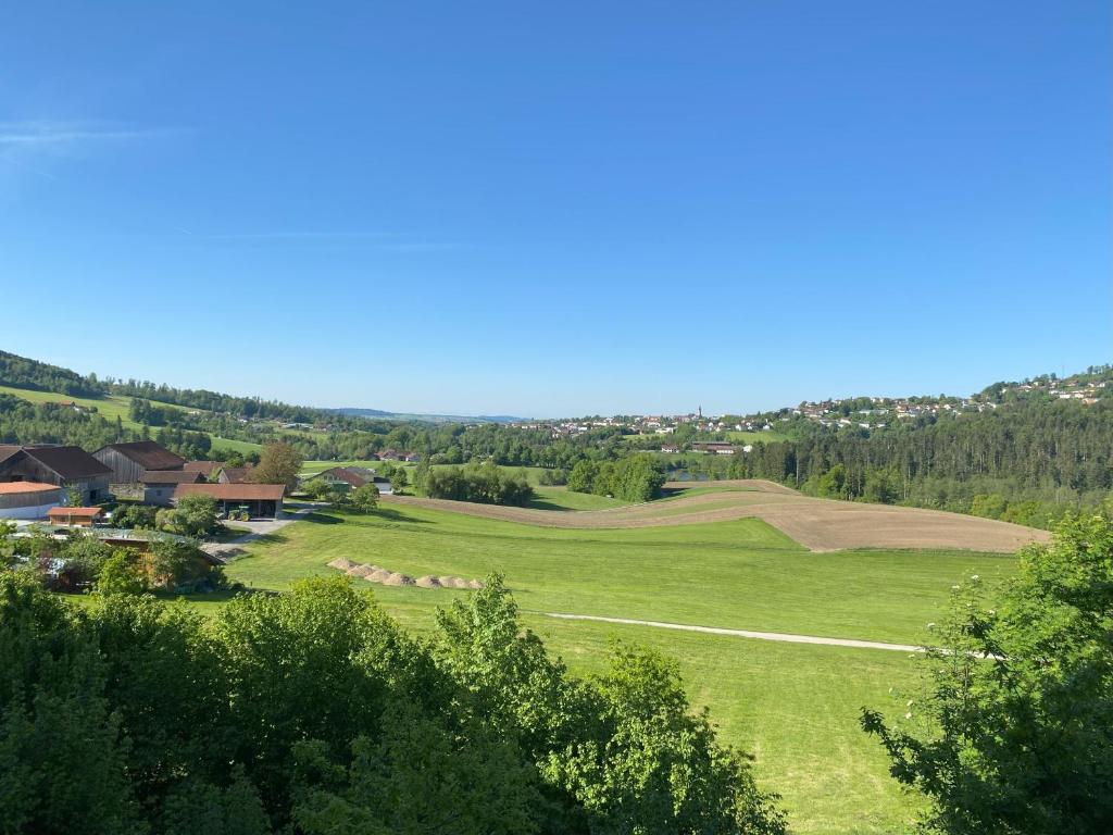 a green field with trees and houses in the distance at Fe-Wo Berg und See in Hauzenberg