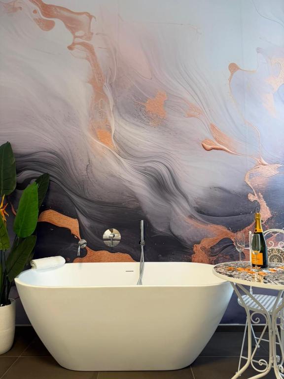a bathroom with a bath tub and a table at Dimora Perrini in Fasano