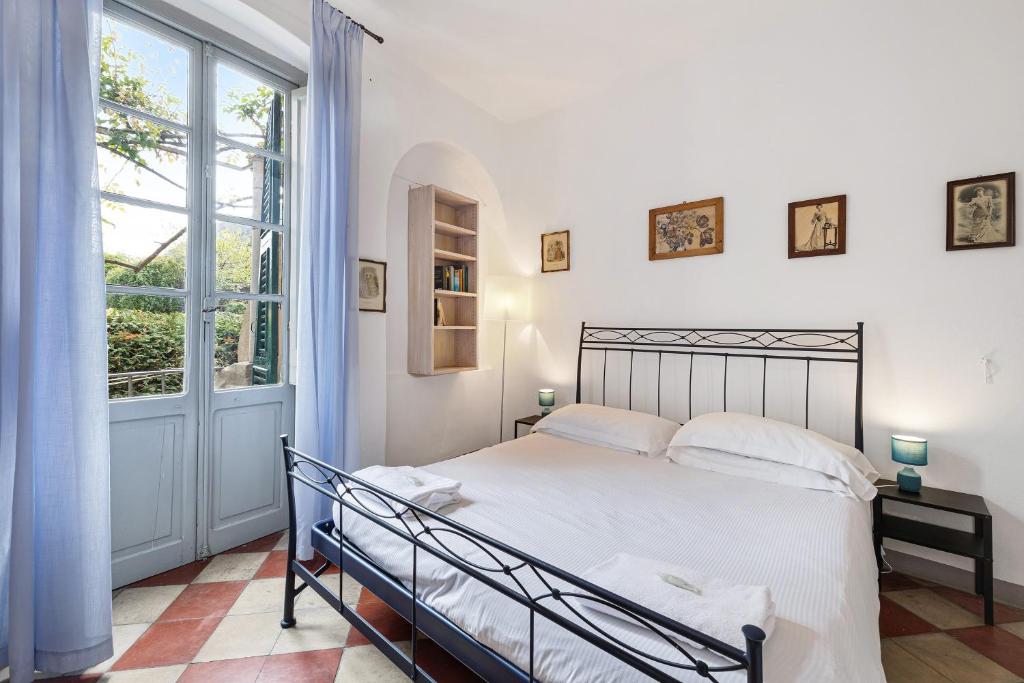 a bedroom with a bed and a large window at Monolocale Isotta in Finale Ligure