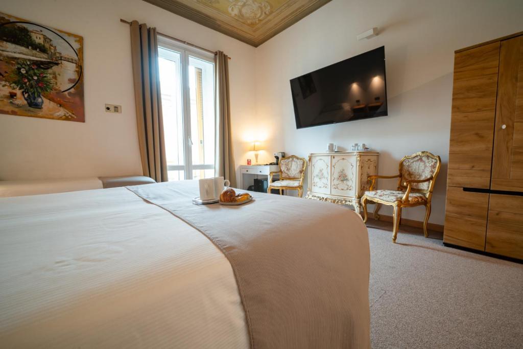a bedroom with a large bed with a tv on the wall at Hotel Genova Liberty in Genoa