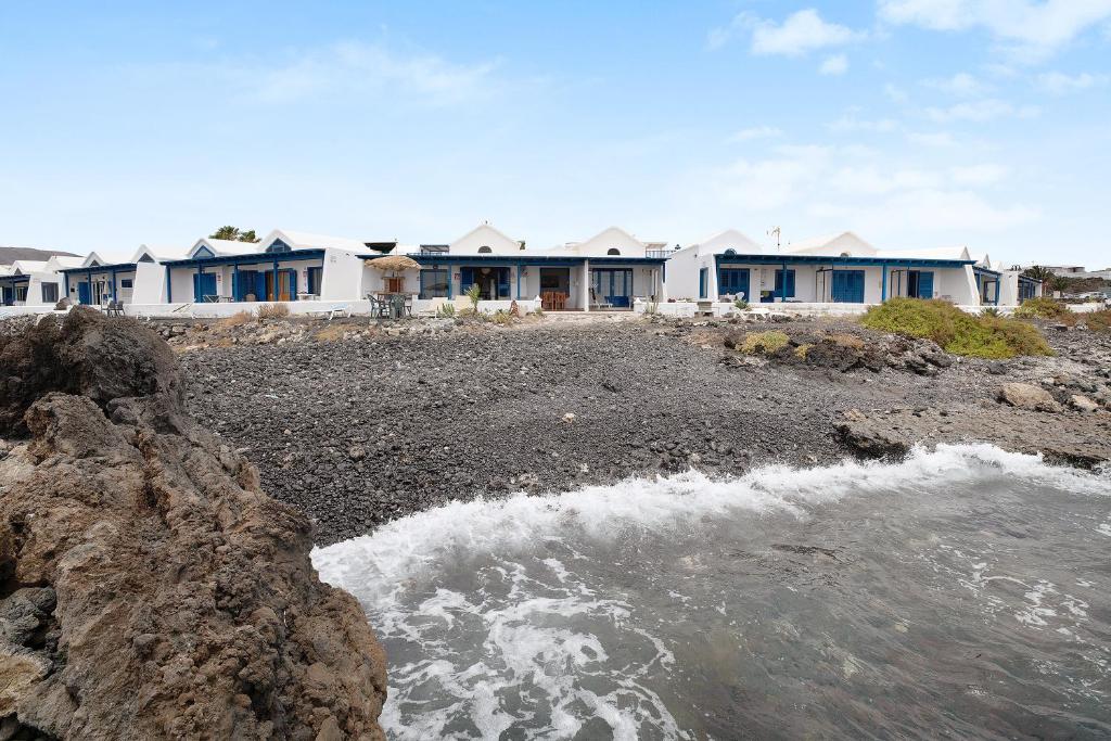 a group of houses on a rocky beach with water at Punta Marea in Punta Mujeres