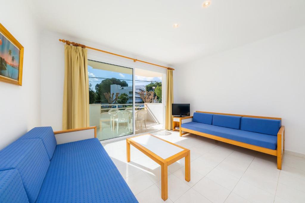 a living room with a blue couch and a table at Apartament Massanet bc in Canyamel