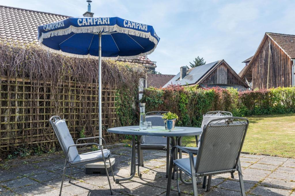 a table and chairs with an umbrella on a patio at Ferienwohnung Rothmund in Überlingen
