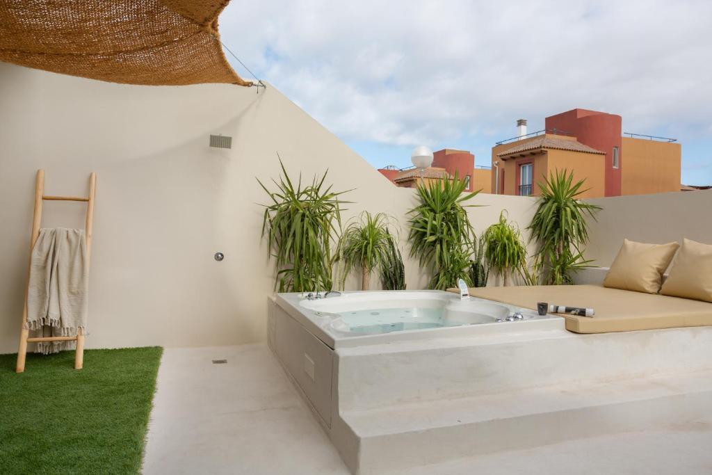 a jacuzzi tub on a patio with plants at Casa Marea - Villa Con Jacuzzi in Corralejo