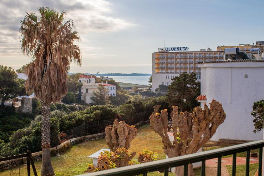 a view of a city from a balcony with palm trees at Apartamento Cala en Forcat 34 in Cala en Blanes