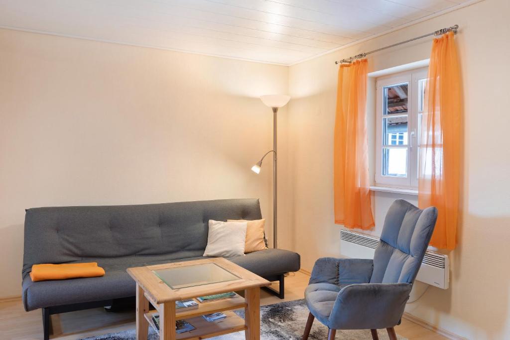 a living room with a couch and a chair at Ferienwohnung im alten Vierseithof in Friedewald