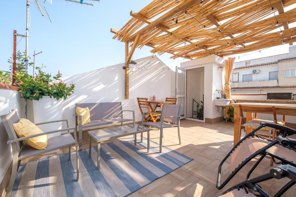 a patio with tables and chairs and a wooden pergola at Mira casa in Spadafora