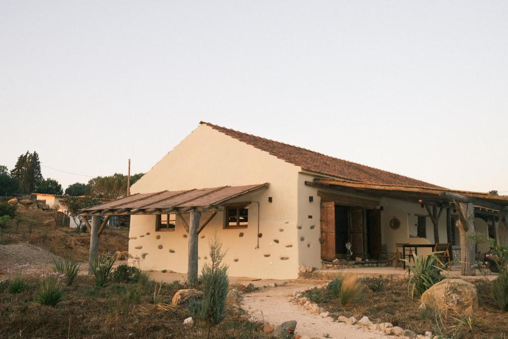 a small white house with a rusty roof at Helder Farm Studios in São Teotónio