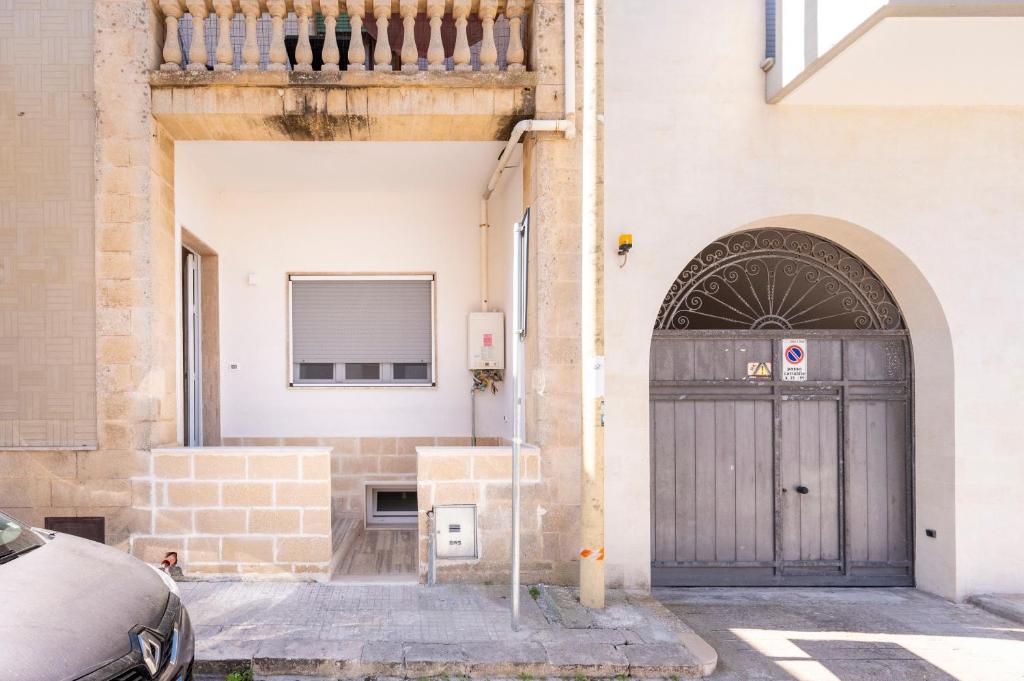 a building with a black door on a street at Micenei Homes in Otranto