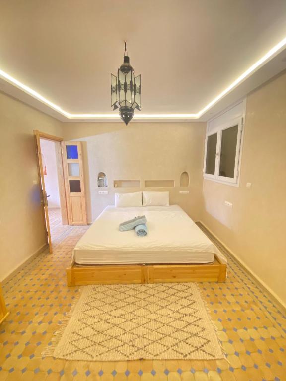 a bedroom with a bed and a chandelier at Mirage House in Mirleft