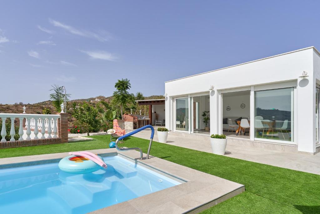 a swimming pool in a yard with a house at Entre montañas in Árchez