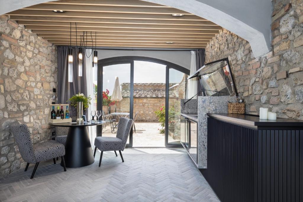 a room with a bar with a stone wall at Suite Orcio in San Gimignano