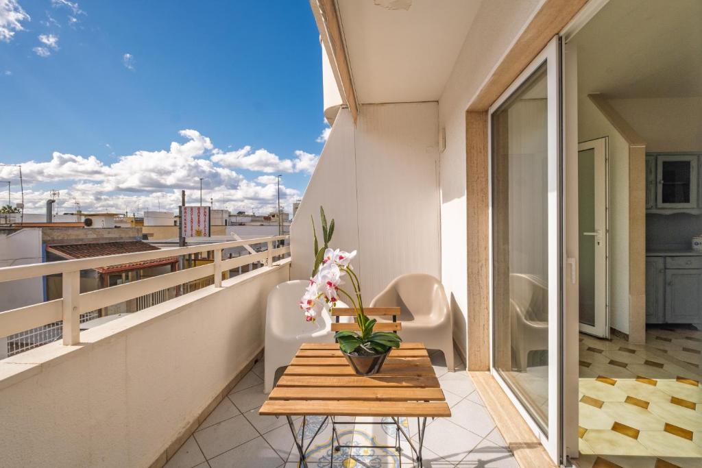 a balcony with a table with flowers on it at Blue Bay Lux House in Torre Lapillo