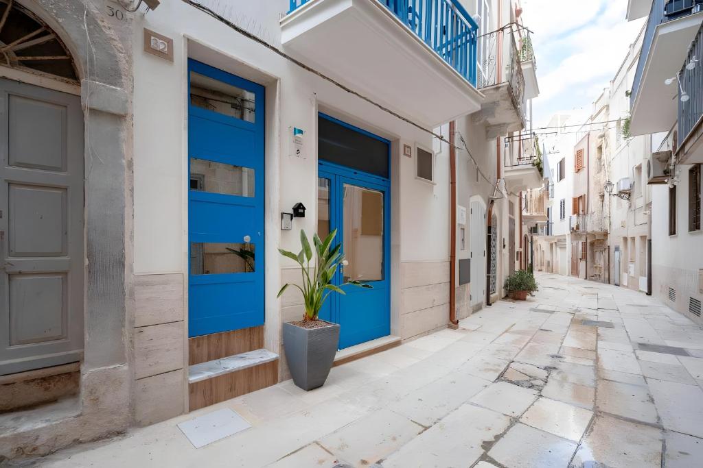 a street with blue doors in an alley at Dimora Don Gabriele e Suite in Mola di Bari