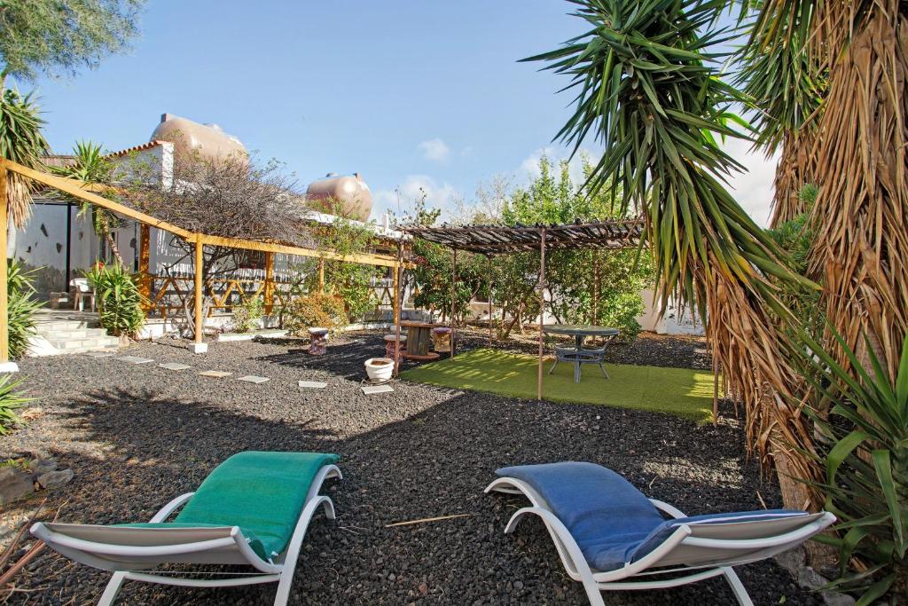 a patio with two chairs and a table and grass at Finca Fani 4 in Agüimes