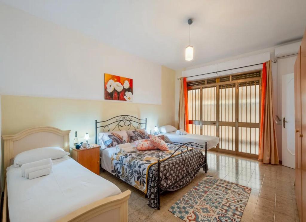 a bedroom with two beds and a window at Villa Tramonto Ionico Torre Lapillo in Torre Lapillo