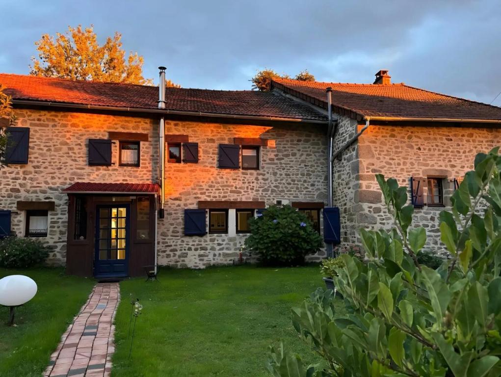 a large brick house with a yard at Chambre d'hôtes - Els Pomers in Soubrebost