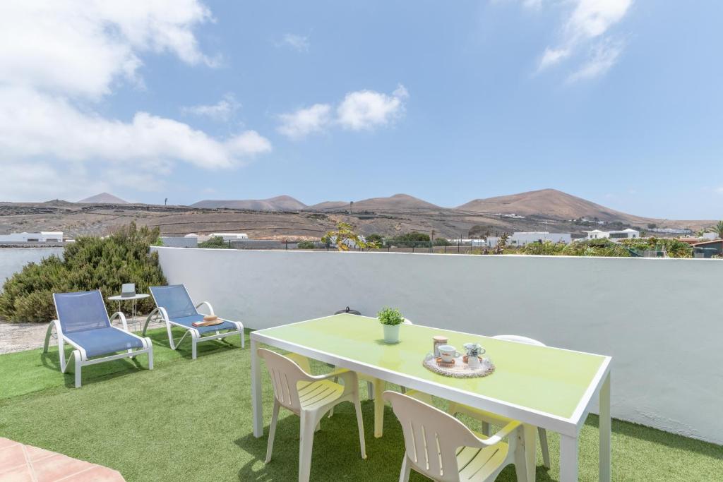 a patio with a table and chairs on the grass at Apartamento La Dehesa - Uga in Uga