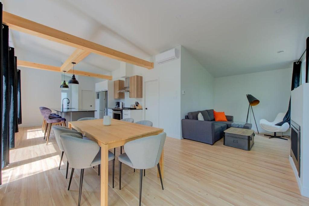 a dining room and living room with a table and chairs at La Relache - Nature & Relaxation - Pet Friendly in Pont-Rouge