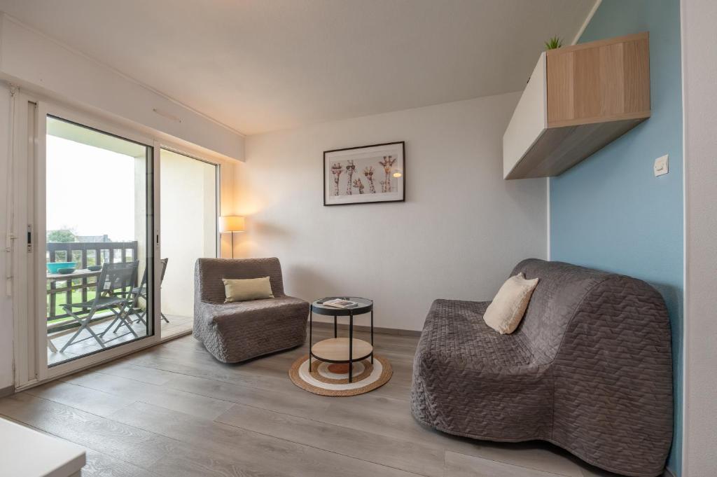 a living room with a couch and a chair at Le Sailing,parking, proche plage in Arzon