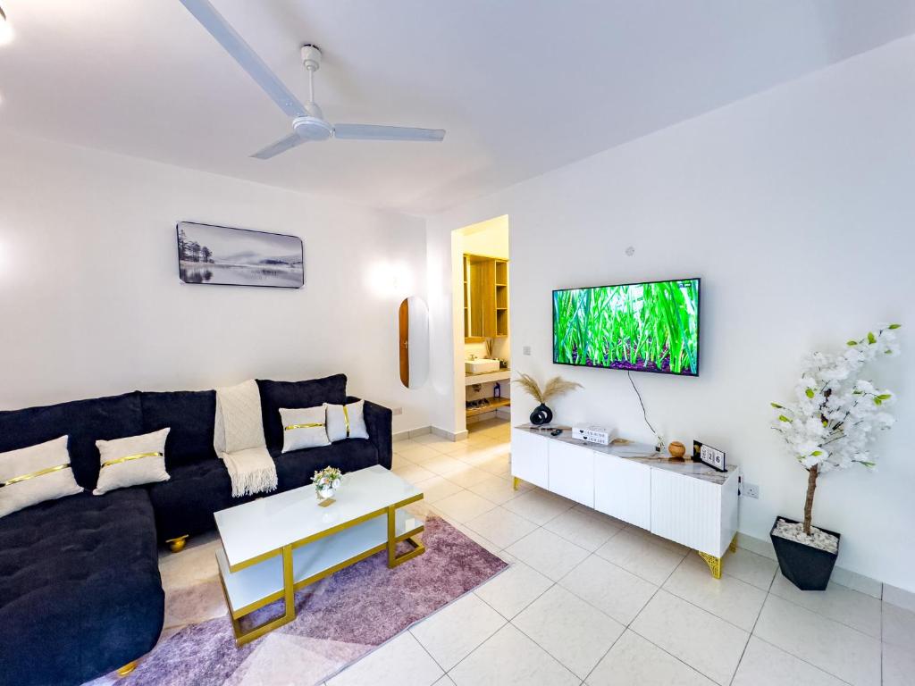 a living room with a couch and a tv at Diani Hideouts 2 in Kwale