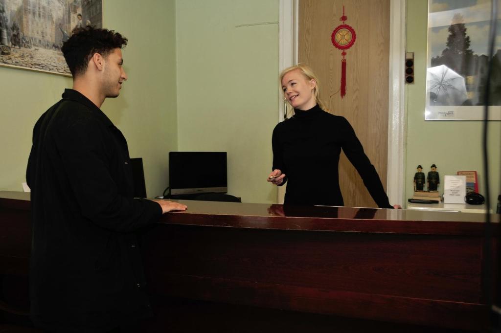 a man and a woman standing at a reception desk at Hotel Euroglobe in Copenhagen