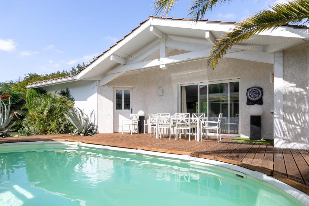 a house with a swimming pool in front of a house at Maison De Vacances 8pers Seignosse in Seignosse