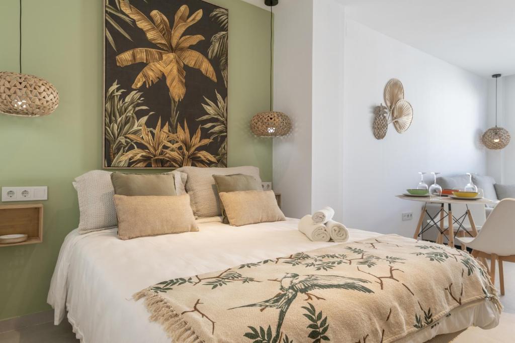 a bedroom with a bed with a large painting on the wall at Apartamento The Banana Tree 2 9 in Tarifa