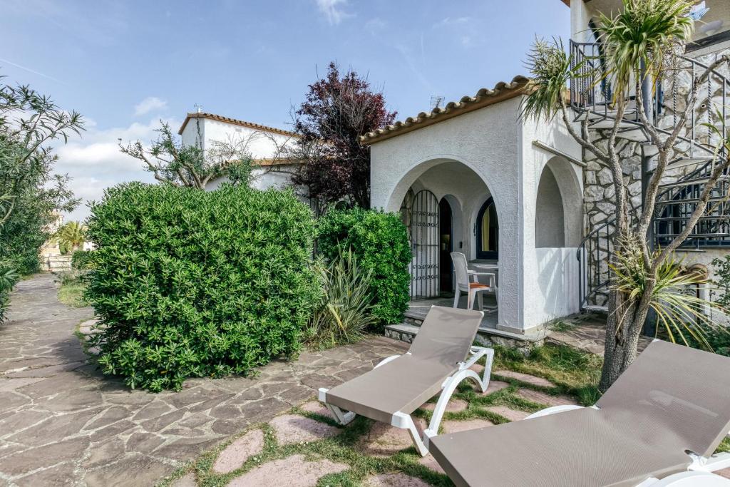 a patio with two chairs and a table at Art- Apartamentos Revilla Tacke E in Empuriabrava
