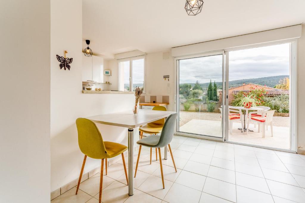 a kitchen and dining room with a table and chairs at Gîte du Badassier in Blauvac