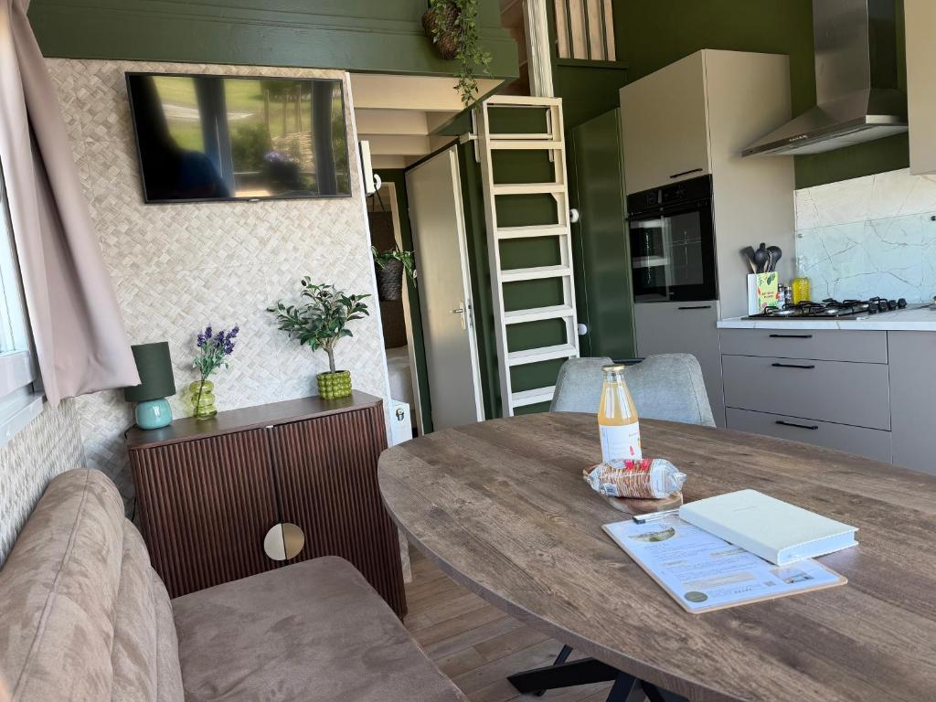 a kitchen and a table in a tiny house at De Meerkoet Tiny House Tussen de Dijken in Driewegen