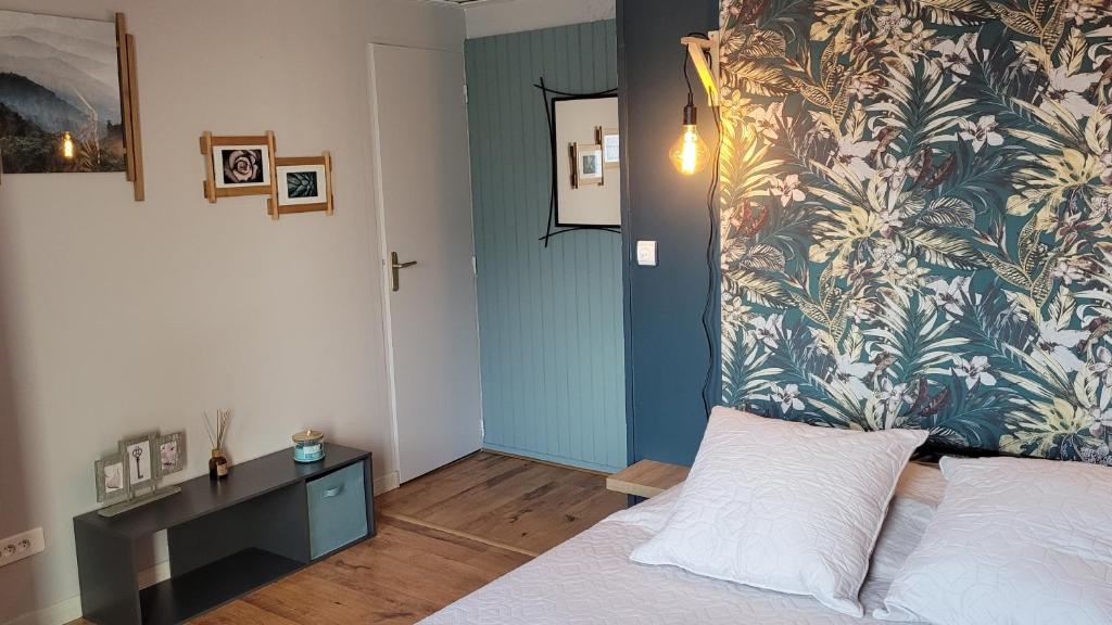 a bedroom with a bed and a floral wall at Le Gîte du Chauze in Meyssac