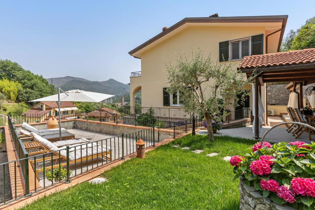 a house with a fence and a yard with a fire hydrant at Villa Lepre in Casarza Ligure