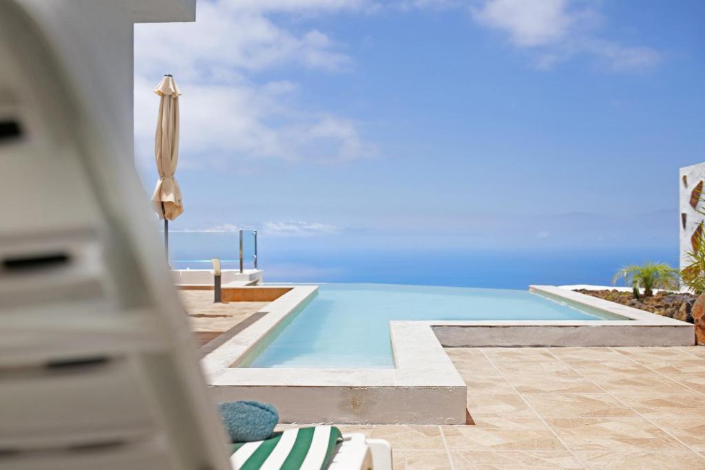 a swimming pool with a umbrella and a swimming pool at Casa Valista in Tijarafe