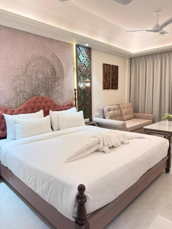 a bedroom with a large white bed and a couch at Vetiver Grand in Jabalpur