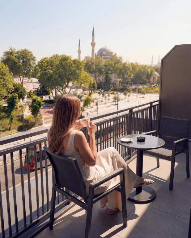 a woman sitting in a chair on a balcony at Edition Old City Hotel in Istanbul
