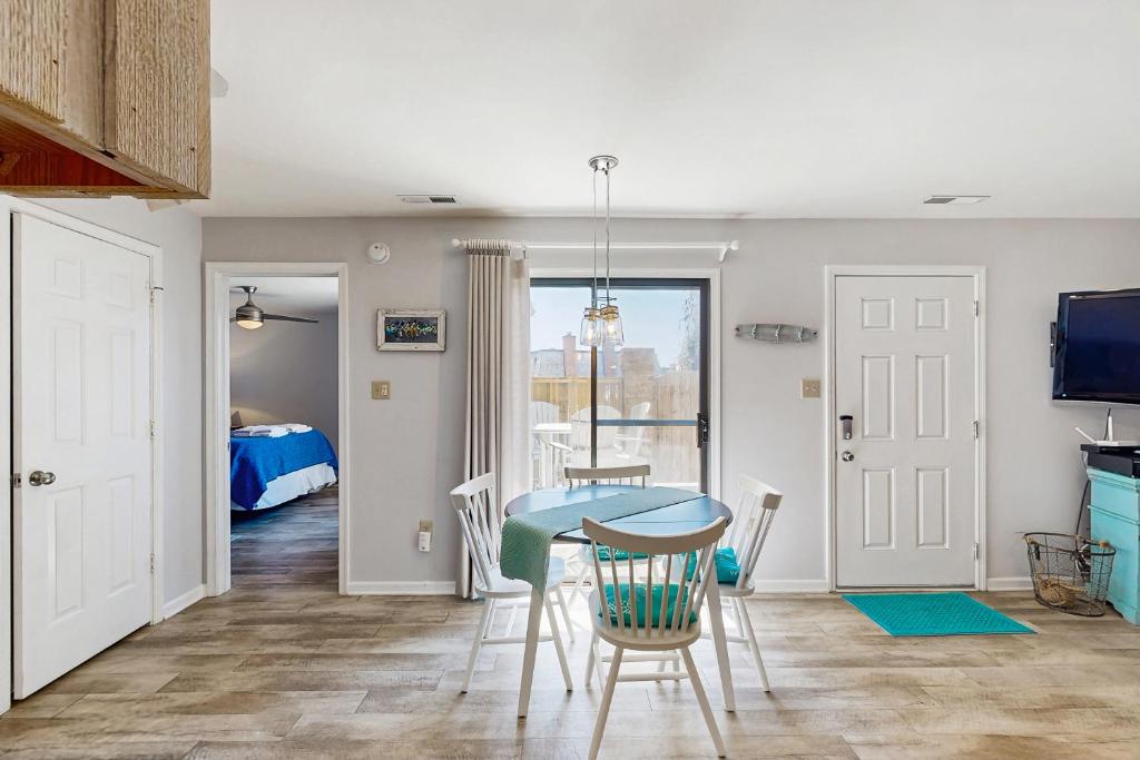 a room with a table and chairs and a bedroom at Sandy Bottom VROBX in Kitty Hawk