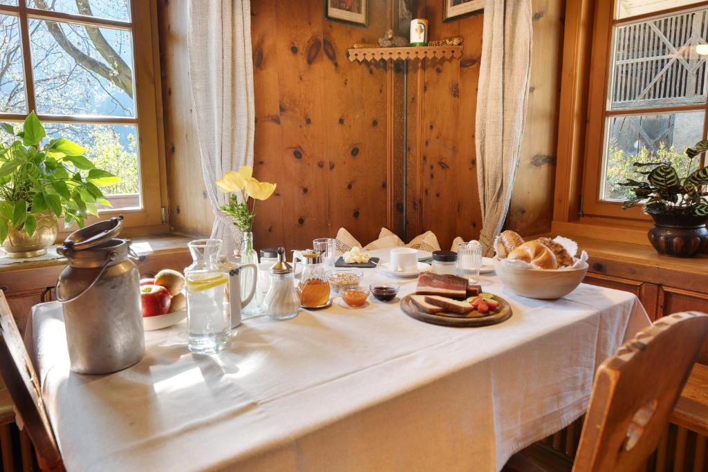 a white table with food and bread on it at Mayrhof Zimmer, Bauernhofurlaub in San Pancrazio dʼUltimo