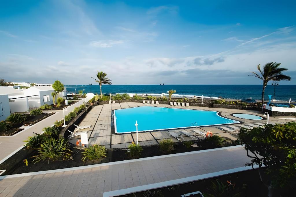 a swimming pool with the ocean in the background at Bungalow 7 - Caleta Campos in Arrieta