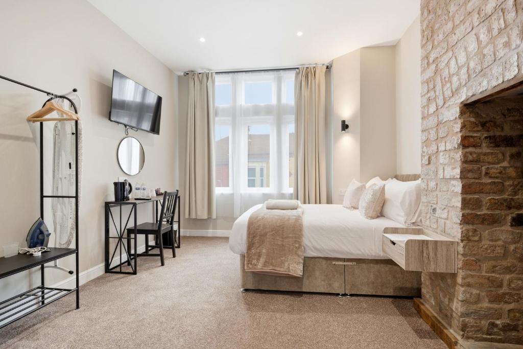 a bedroom with a bed and a brick wall at The Stuart Hotel in Liverpool