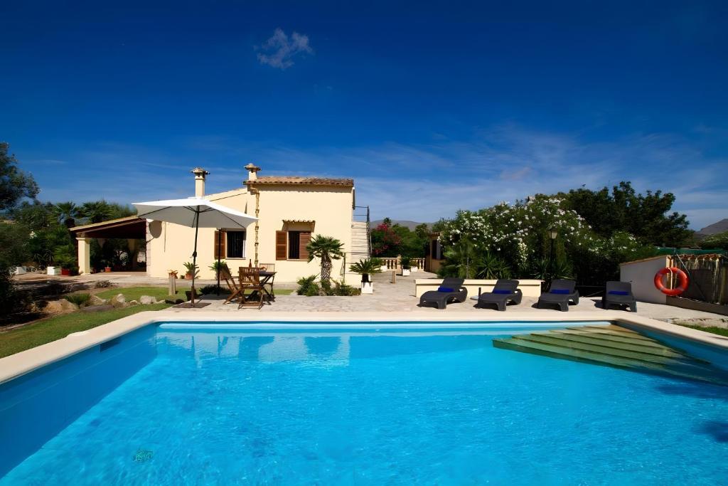 a villa with a swimming pool in front of a house at Villa L´Embat in Pollença