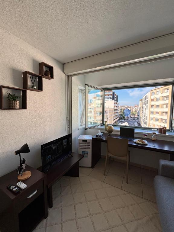 a living room with a desk and a large window at La nuit Douce in Annemasse
