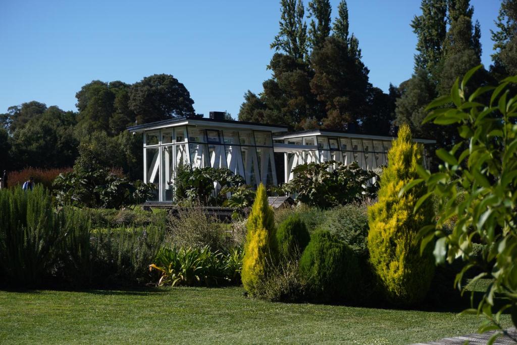 a white building in the middle of a garden at Hotel Gran Wolf - Haras Santa Amelia in Negrete