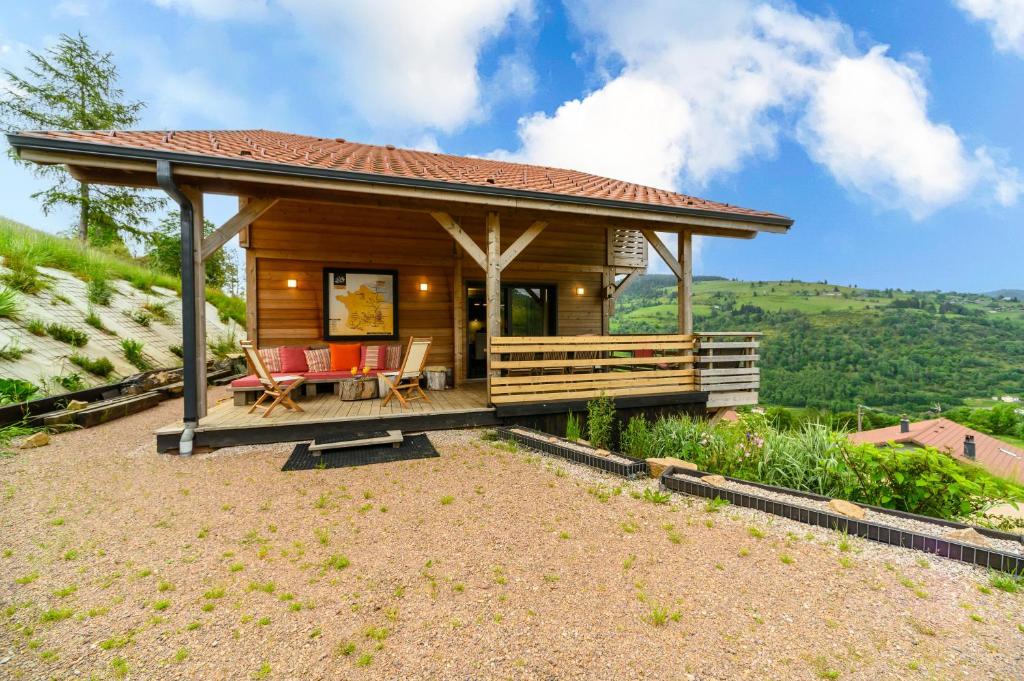 a log cabin with a porch and a patio at Le Chalet Milien in La Bresse