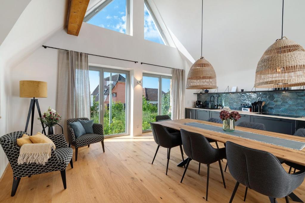 a kitchen and dining room with a large wooden table and chairs at Das Alte Pfarrhaus - Scheune in Gleisweiler