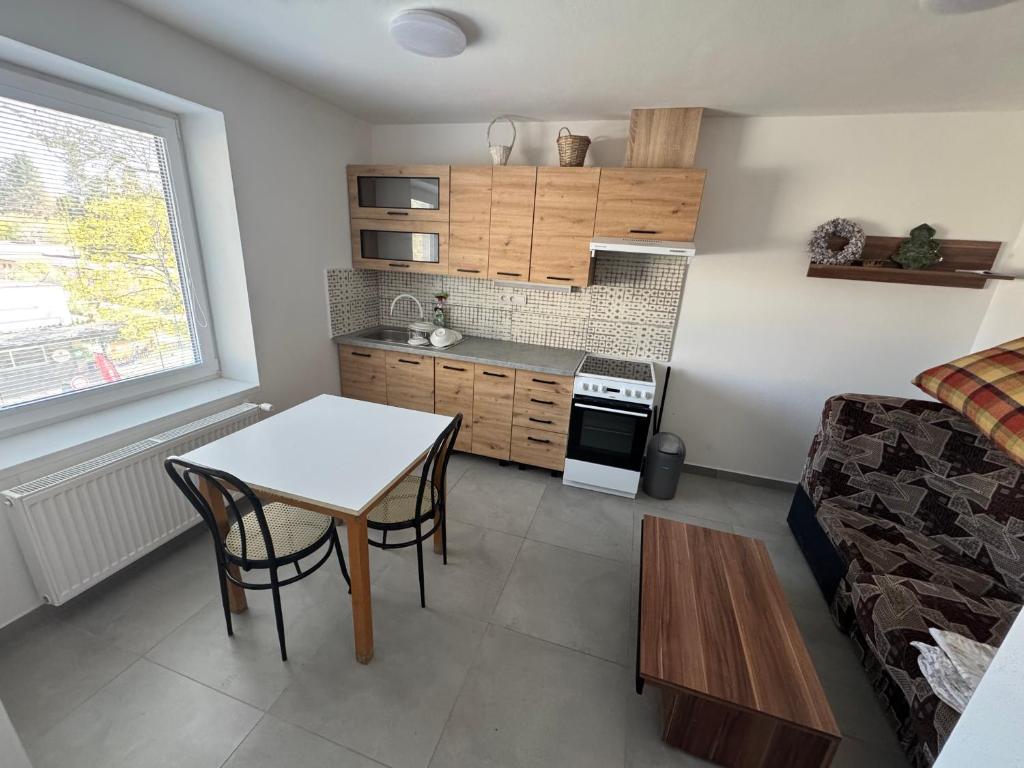 a small living room with a table and a kitchen at Tatrabyt in Bánovce nad Bebravou