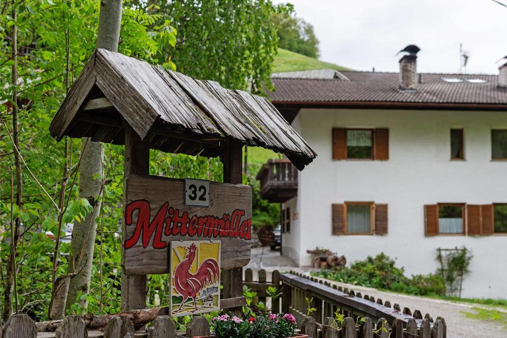 a wooden sign in front of a house at Mittermüllerhof Feldthurns in Velturno