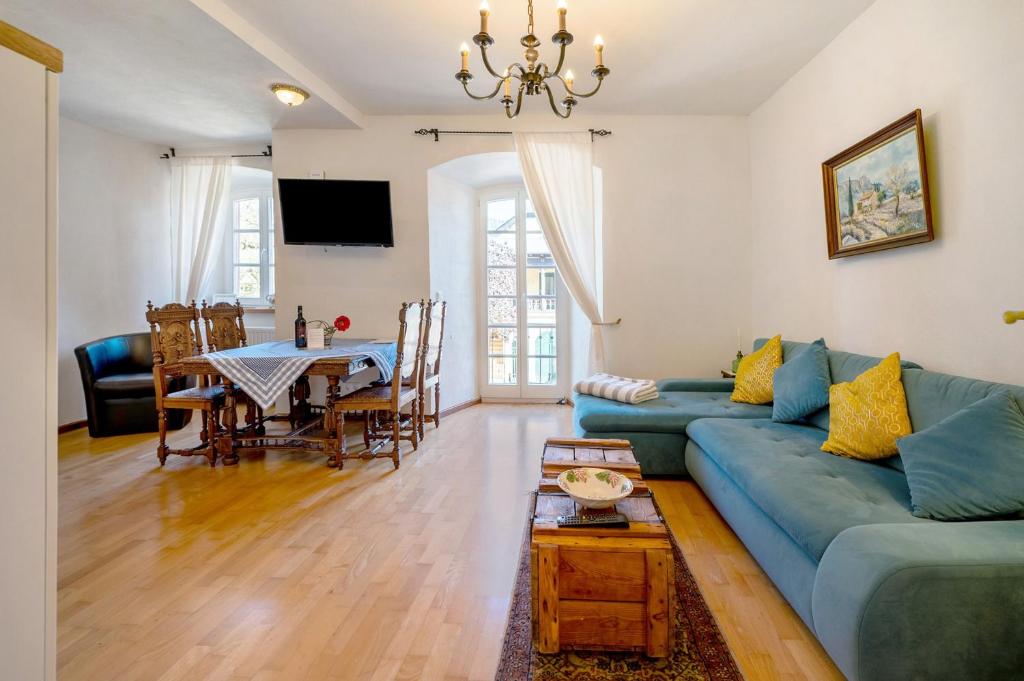 a living room with a blue couch and a table at Ferienwohnung Schatztruhe in Maring-Noviand
