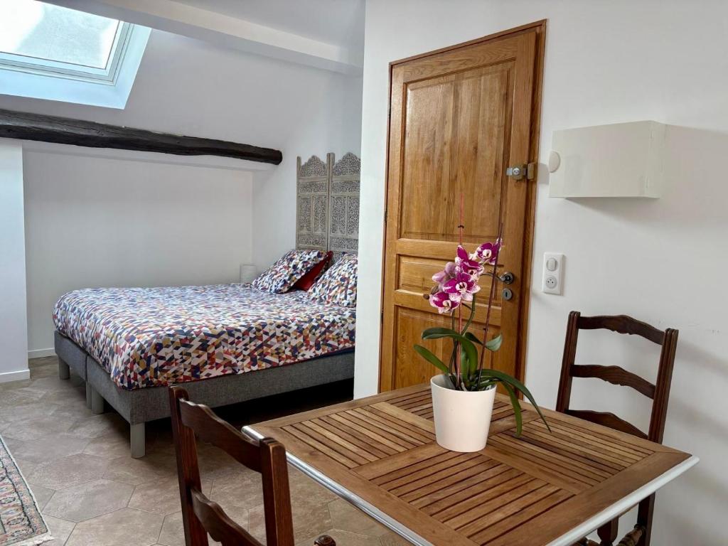 a room with a table and a bedroom with a bed at VILLA.H GARDEN in Cramant