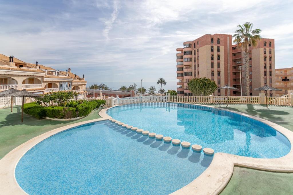 a swimming pool at a resort with buildings at Playa Arenales del Sol in Arenales del Sol